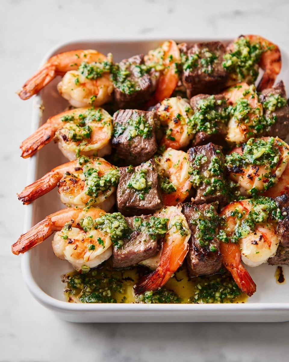 A rectangular white enamel tray holds several grilled shrimp and beef kebabs arranged closely together. Each skewer has alternating pieces of pink-orange shrimp with slightly charred edges and brown, juicy beef cubes. Both shrimp and meat are topped with a drizzle of green garlic herb sauce, which is finely chopped and fresh, giving a bright contrast to the cooked food. The tray rests on a white marbled surface, enhancing the fresh and clean look of the dish. photo taken with an iphone --ar 4:5 --v 7