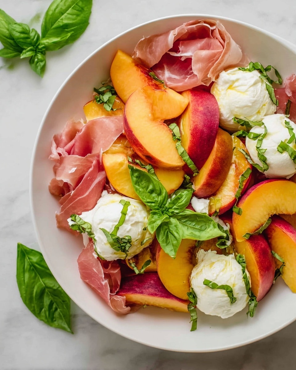 The dish is presented in a white bowl on a white marbled surface, with three layers clearly visible. The bottom layer consists of thinly folded pink prosciutto slices, creating a soft and slightly wrinkled texture. On top of the prosciutto, bright orange and red peach slices form the second layer, their smooth, juicy skin adding vibrant color contrast. The third layer is made of dollops of soft, white burrata cheese, placed evenly over the peaches, with small green basil leaves scattered on and around the cheese for a fresh touch. Photo taken with an iphone --ar 4:5 --v 7