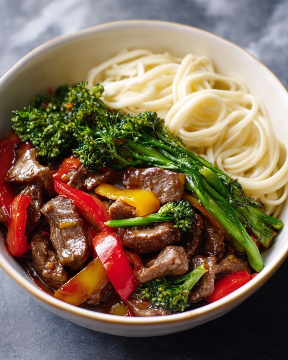 A white bowl filled with three main layers: on one side, there are smooth, pale yellow noodles loosely piled; next to the noodles is a colorful stir-fry mix with tender brown beef slices, bright green broccolini spears, and chunks of red and yellow bell peppers, all coated in a shiny sauce. The white marbled background highlights the vivid colors of the dish, making it look fresh and tasty. photo taken with an iphone --ar 4:5 --v 7