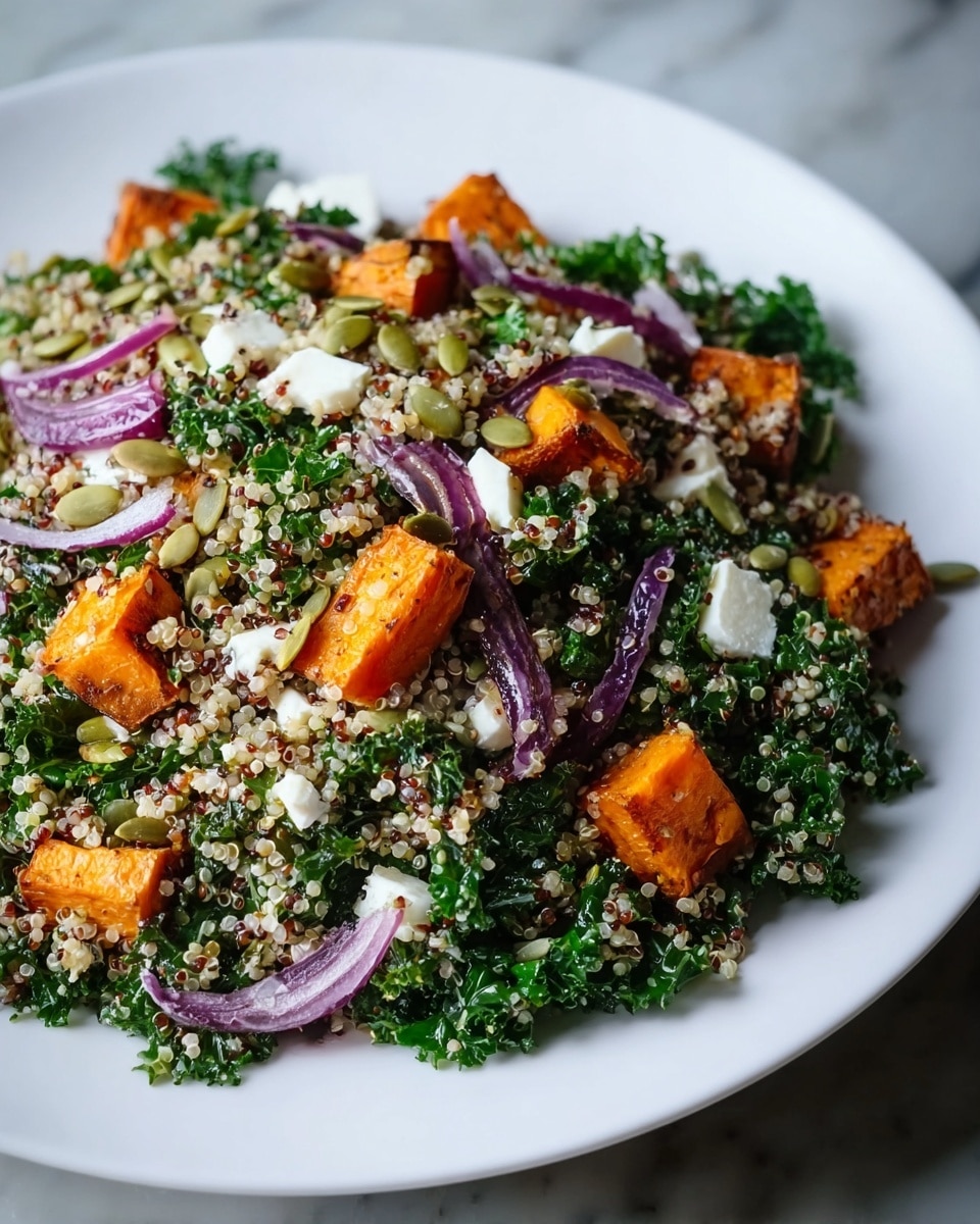 A white plate holds a mixed salad mainly made of a base layer of small, round, translucent quinoa grains with hints of red quinoa, interspersed with finely chopped dark green kale leaves giving a textured and leafy look. Scattered throughout are visible orange roasted sweet potato chunks with a slightly crispy surface, adding contrast and depth. Thin slices of purple onion are spread across, adding a sharp color pop. Small white crumbled cheese bits are sprinkled throughout, adding a crumbly texture. On top, a layer of green pumpkin seeds is unevenly spread, adding a glossy, round, and smooth texture. The white plate rests on a white marbled surface. photo taken with an iphone --ar 4:5 --v 7