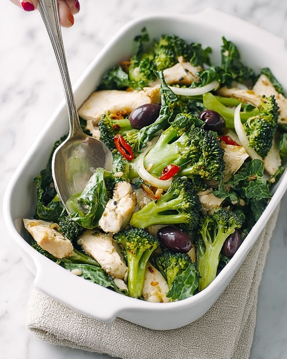 The image shows a white rectangular dish filled with a colorful salad. The bottom layer is made of dark green leafy vegetables, topped with vibrant green broccolini florets with a slightly rough texture. Scattered among the greens are thick slices of pale, cooked white chicken breast and several shiny black olives. Thin slices of red chili peppers add a bright pop of color. A large silver spoon rests on the side of the dish, placed on a beige cloth napkin, with a woman's hand holding it from the top right corner. The whole dish sits on a white marbled surface. Photo taken with an iphone --ar 4:5 --v 7