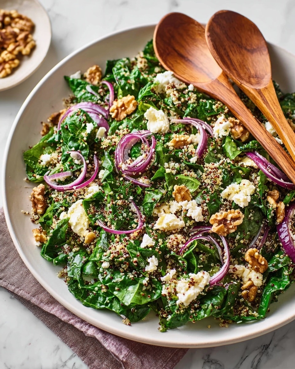 A close-up of a white shallow bowl filled with a fresh salad made of chopped dark green kale leaves mixed with light yellow quinoa grains. Thin slices of purple-red onion are scattered throughout, adding a delicate color contrast. Small pieces of light beige walnuts and crumbles of creamy white cheese are sprinkled on top. Two wooden salad spoons rest at the edge of the bowl. The bowl sits on a white marbled surface. photo taken with an iphone --ar 4:5 --v 7